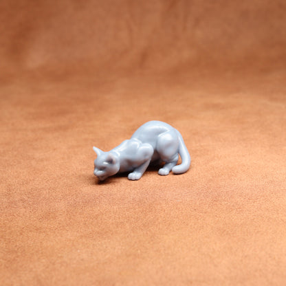 White cat figurine on a brown leather surface