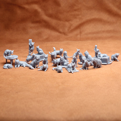 miniature grey resin cat figures on a brow background.