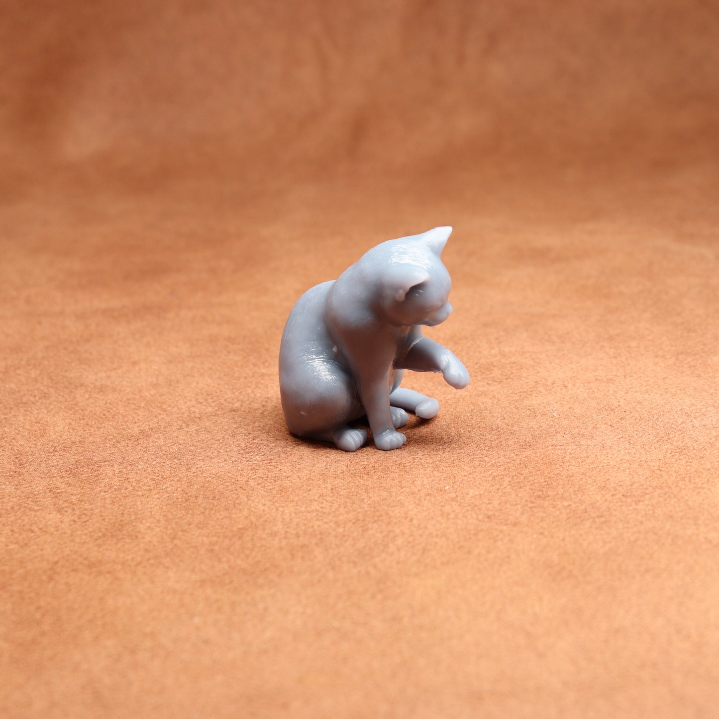 Gray cat figurine on a brown surface