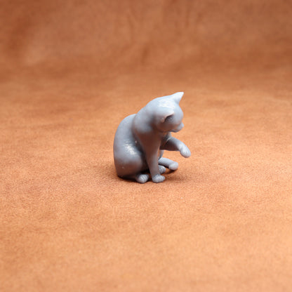 Gray cat figurine on a brown surface