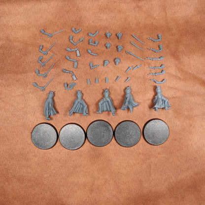 A set of unpainted miniature figurines and accessories for tabletop gaming, including four small character figures with detailed robes and multiple weapon and accessory pieces, arranged on a textured tan leather background. Five round gray bases are shown at the bottom.
