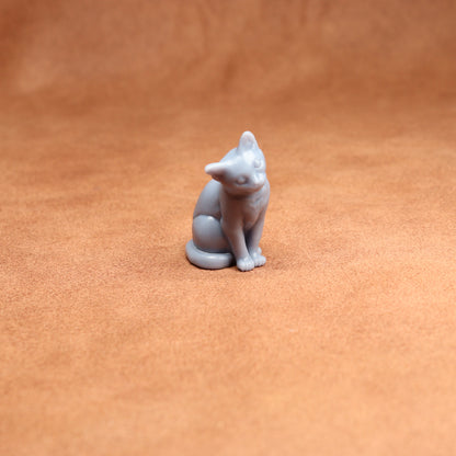 Small gray cat figurine on a brown surface