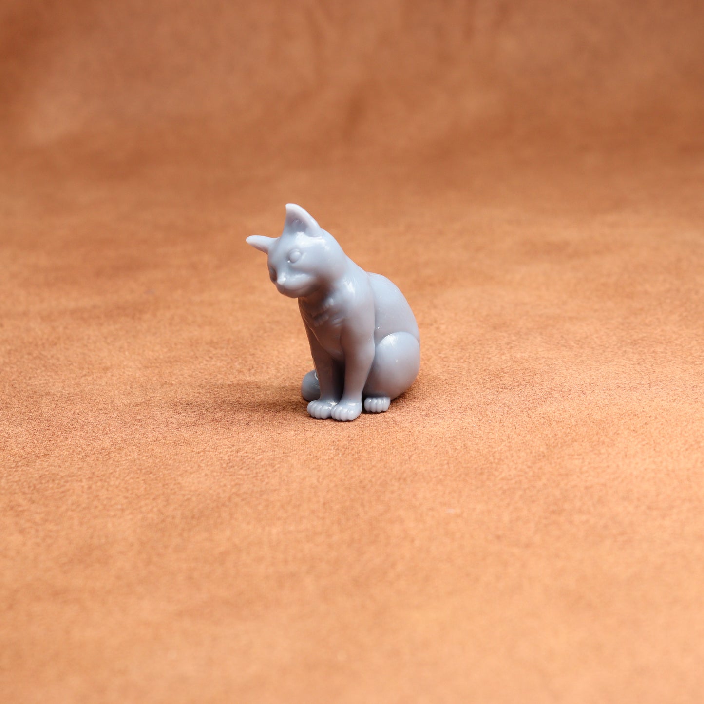 Small white cat figurine on a brown surface
