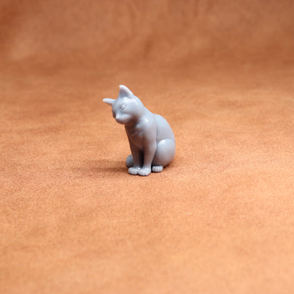 Small white cat figurine on a brown surface