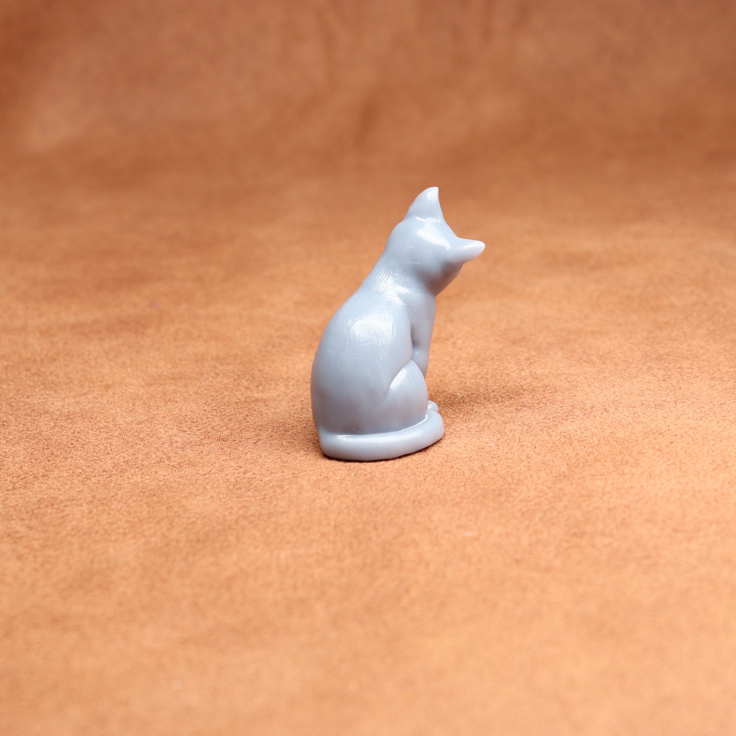 White resin cat figurine on a brown surface