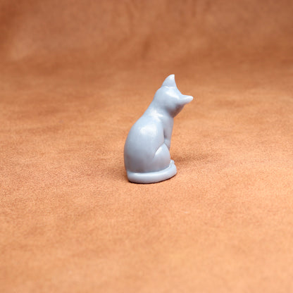 White resin cat figurine on a brown surface