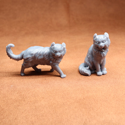 Two gray cat figurines on a brown surface