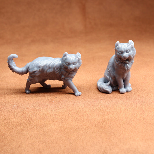 Two gray cat figurines on a brown surface