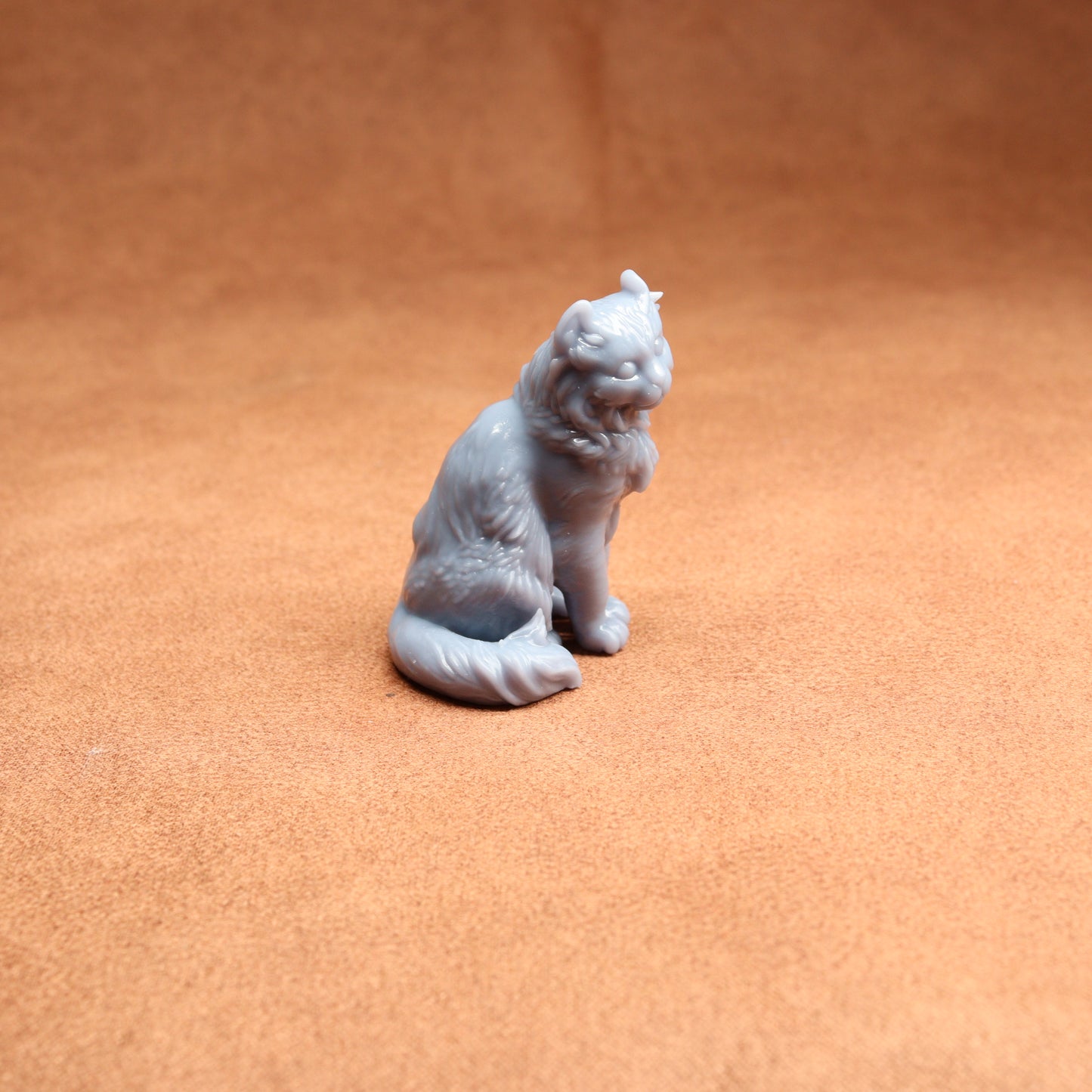 Gray cat figurine on a brown surface