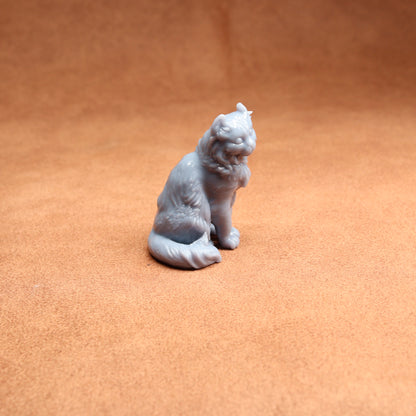 Gray cat figurine on a brown surface