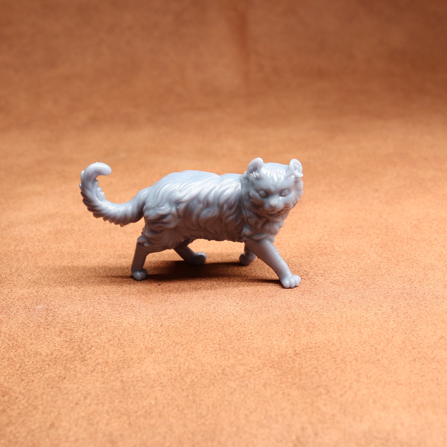 Gray cat figurine on a brown surface