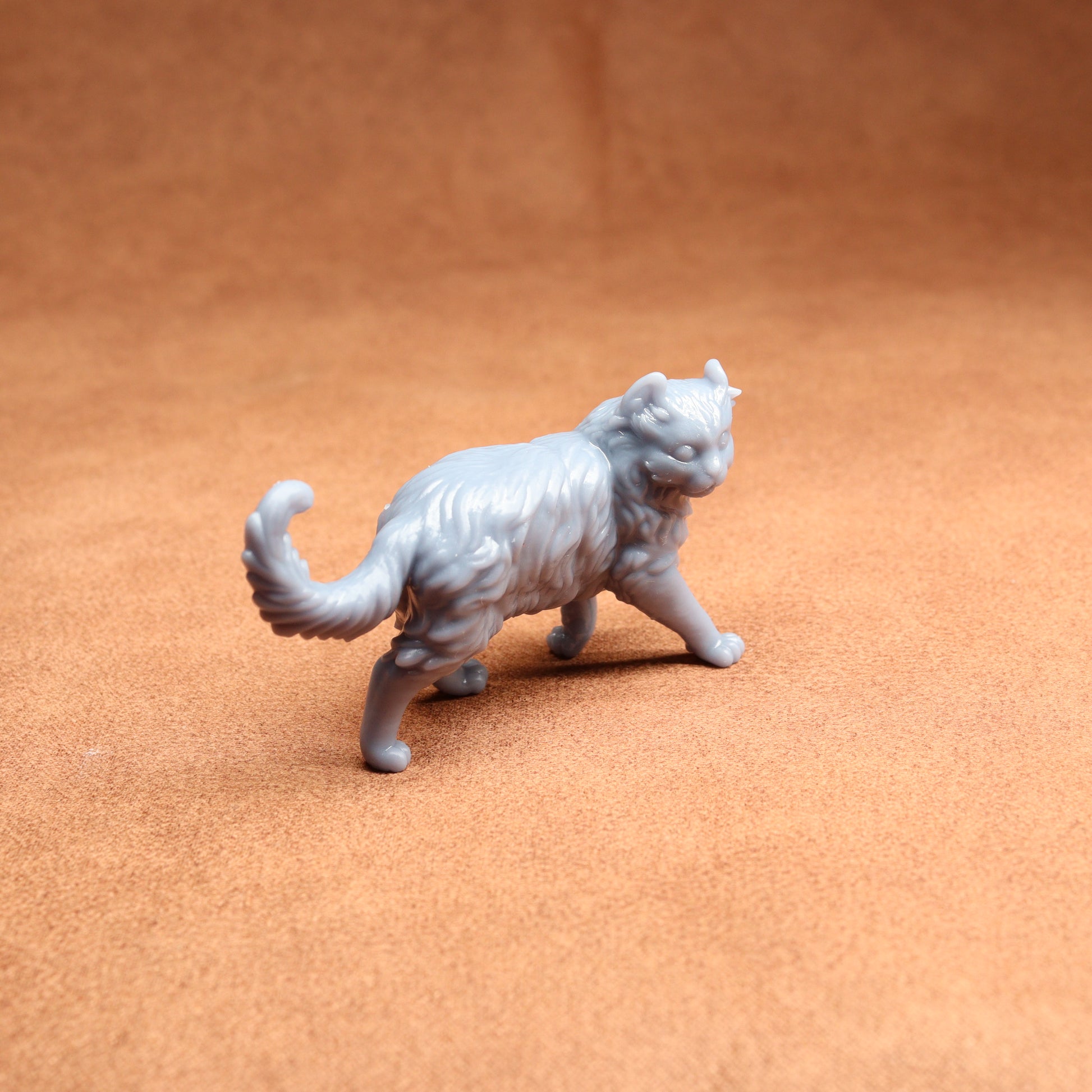 Gray cat figurine on a brown surface