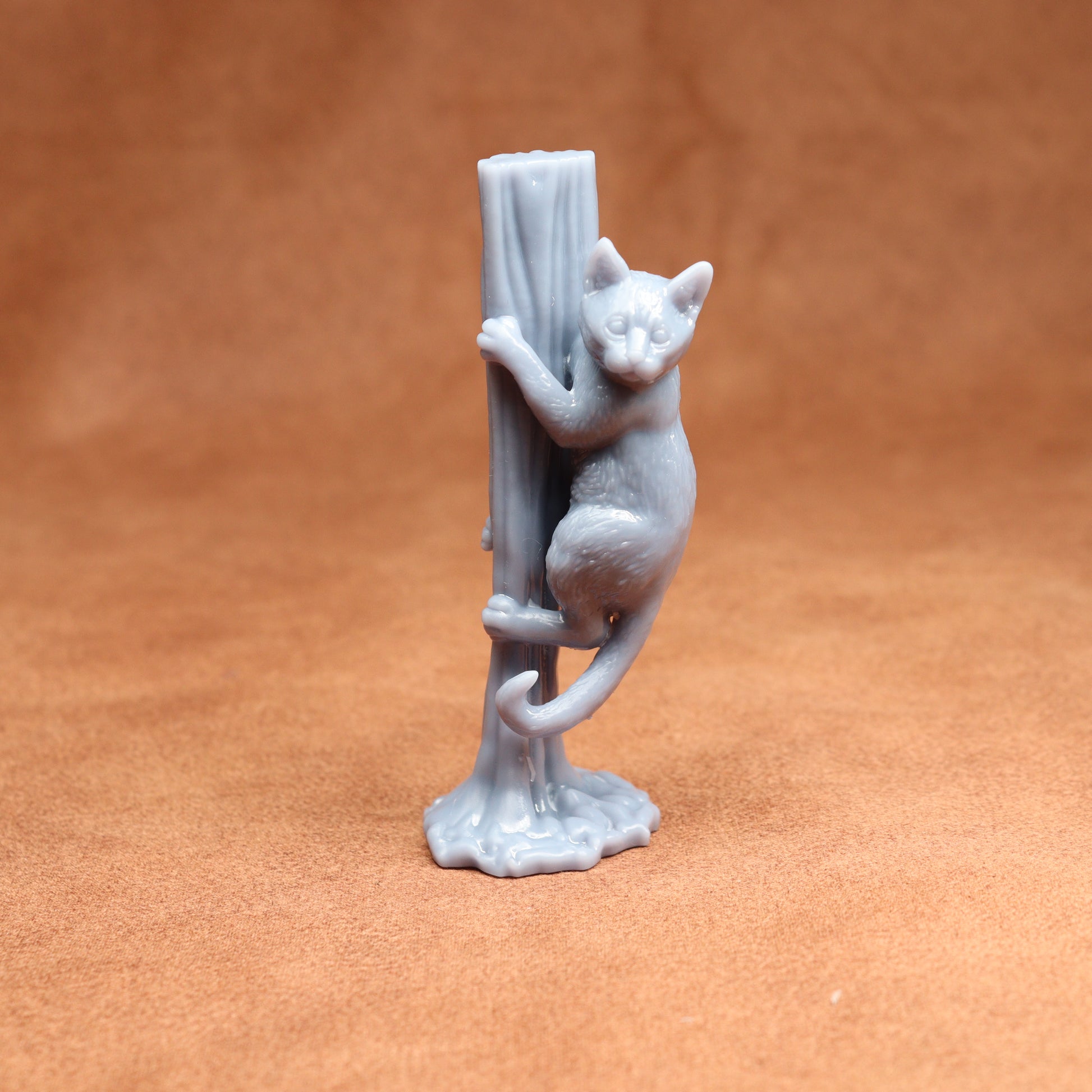 Gray ceramic cat figurine on a brown background