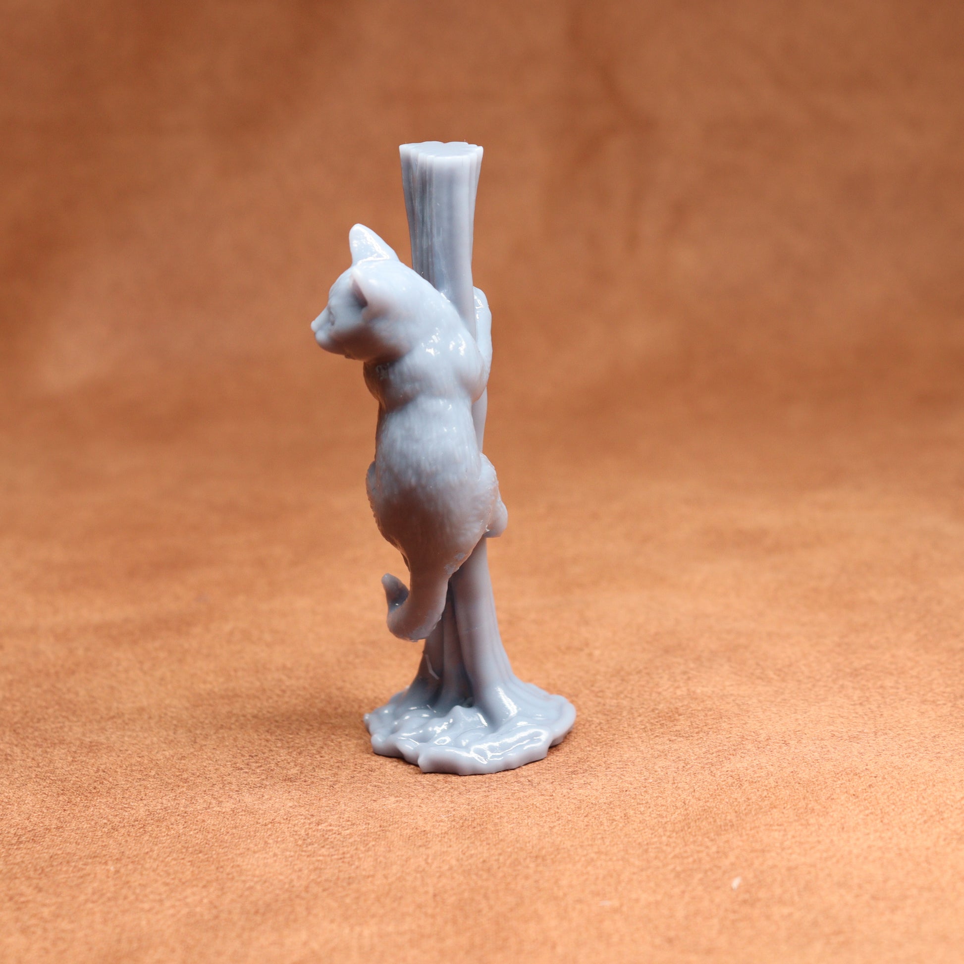 Gray ceramic cat figurine standing on a brown surface