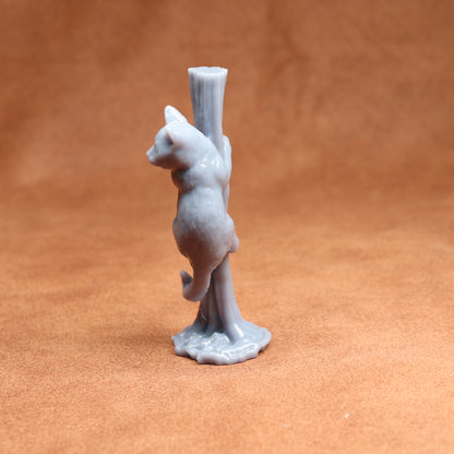 Gray ceramic cat figurine standing on a brown surface