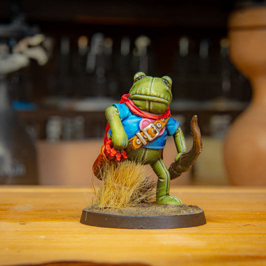 painted frog archer miniature on a wooden surface