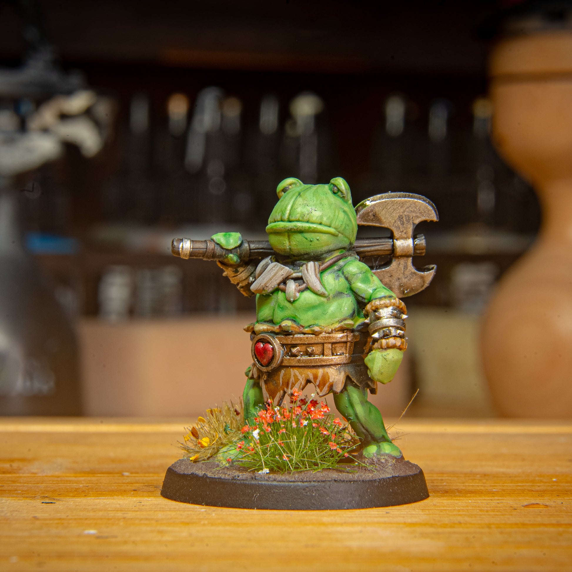 painted frog BARBARIAN miniature on a wooden surface