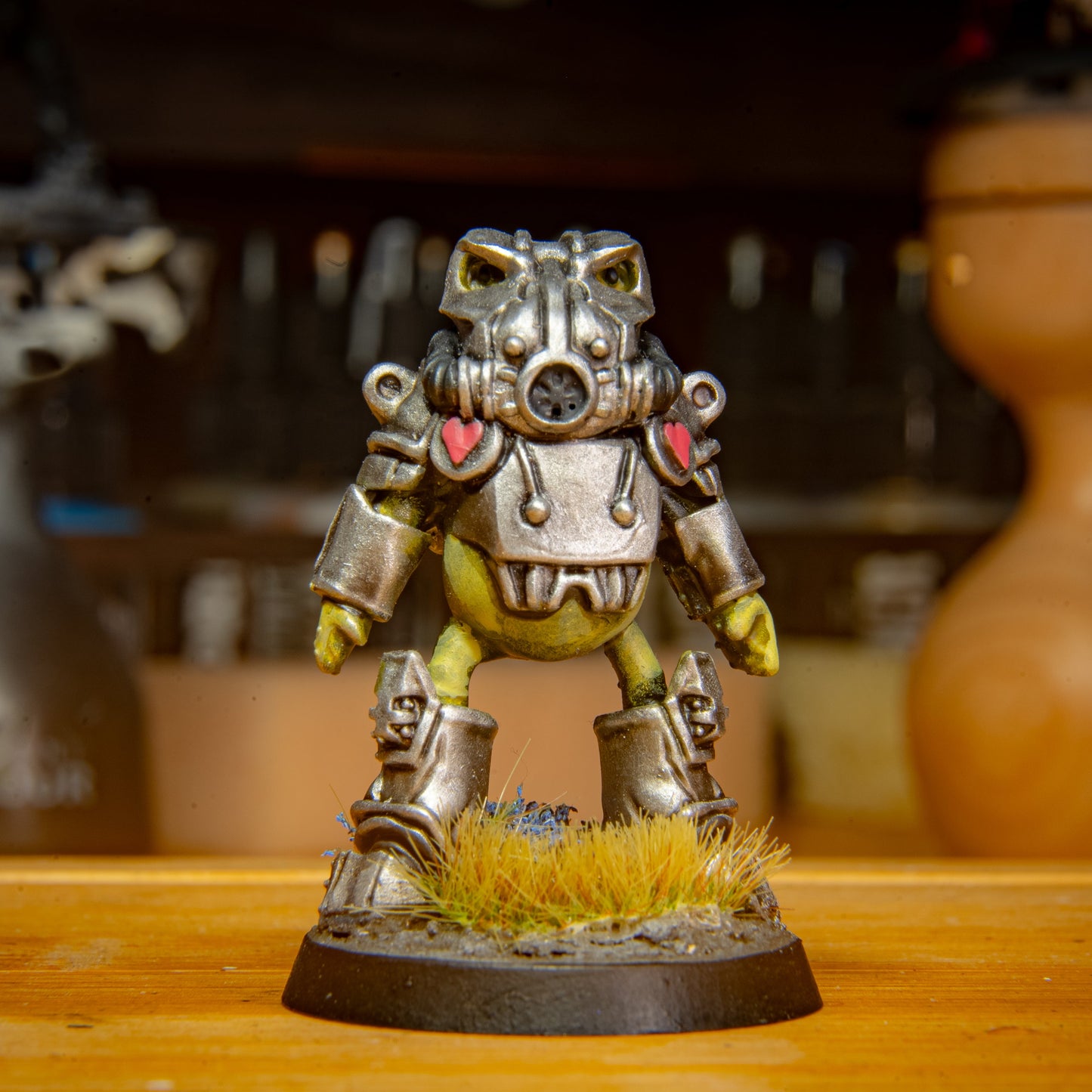 painted frog sci fi armour miniature on a wooden surface