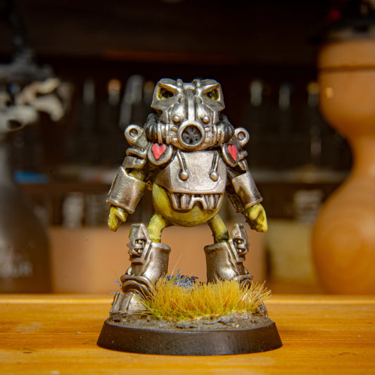 painted frog sci fi armour miniature on a wooden surface