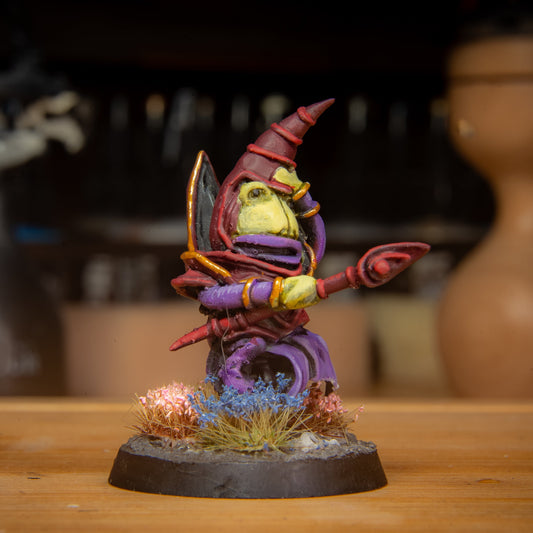 painted frog magician miniature on a wooden surface