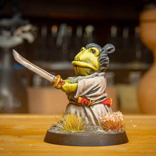painted samurai frog miniature on a brown surface