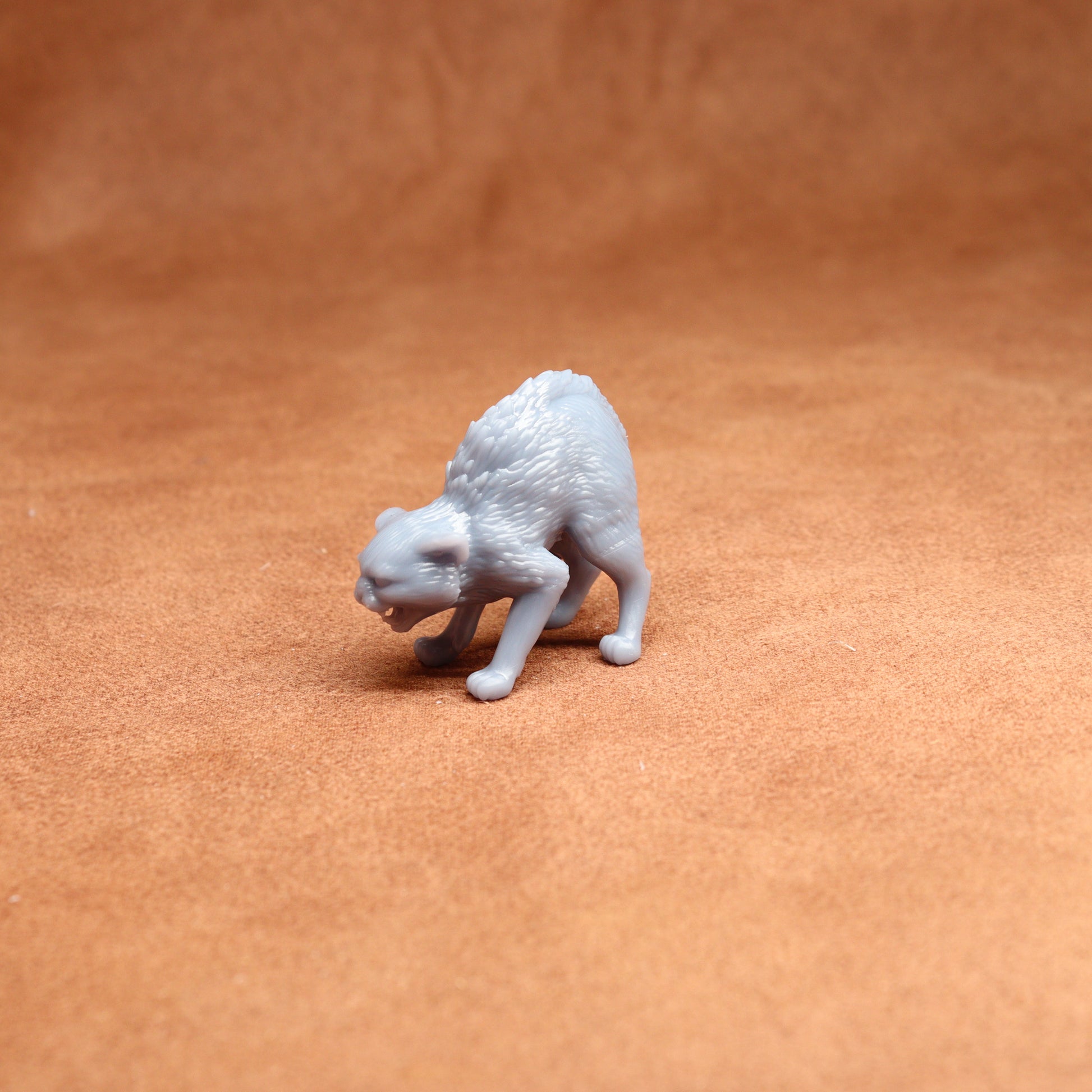 White 3D-printed cat figurine on a brown surface