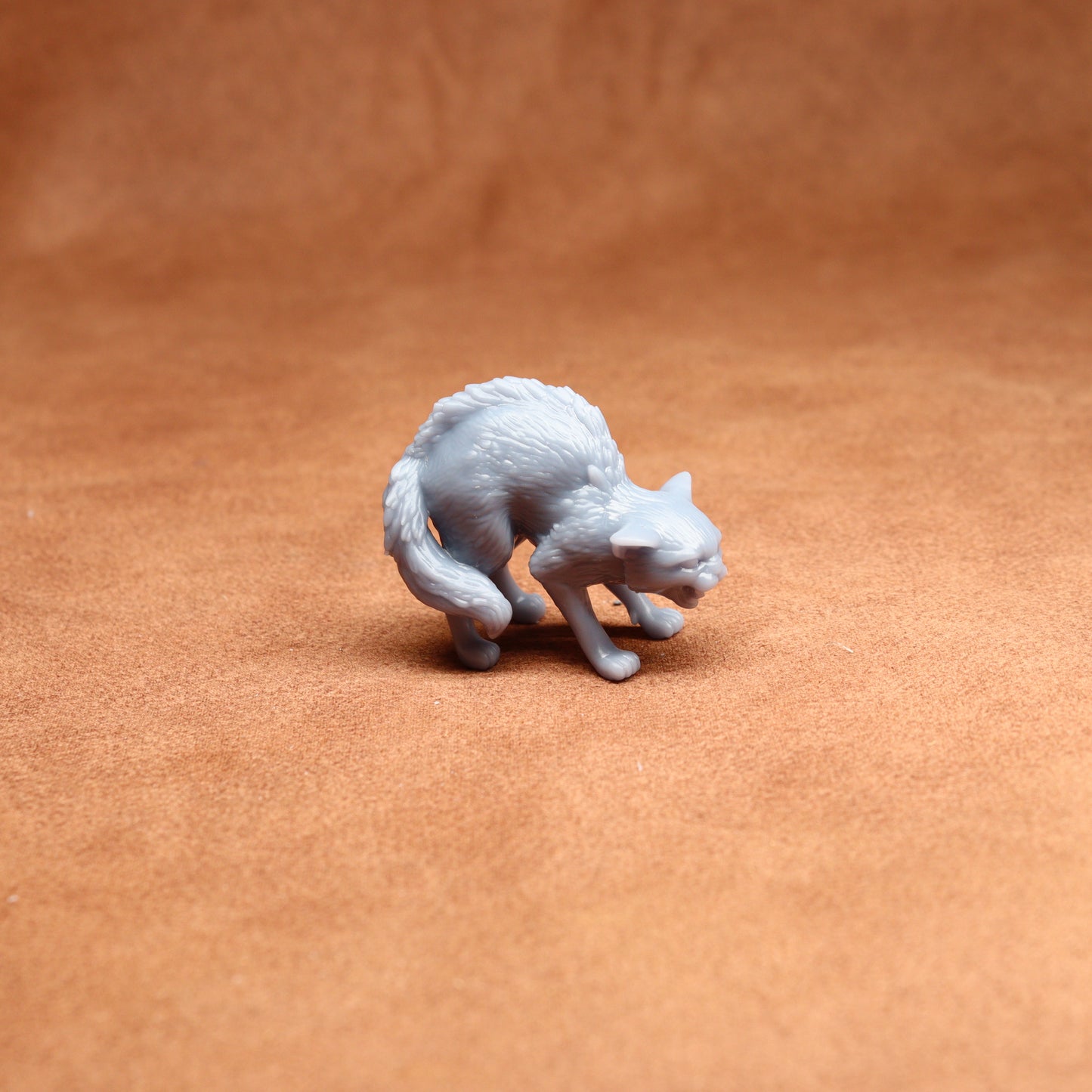 White 3D-printed cat figurine on a brown surface