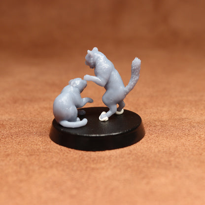 grey resin miniature cat figure on a black base with a brown background