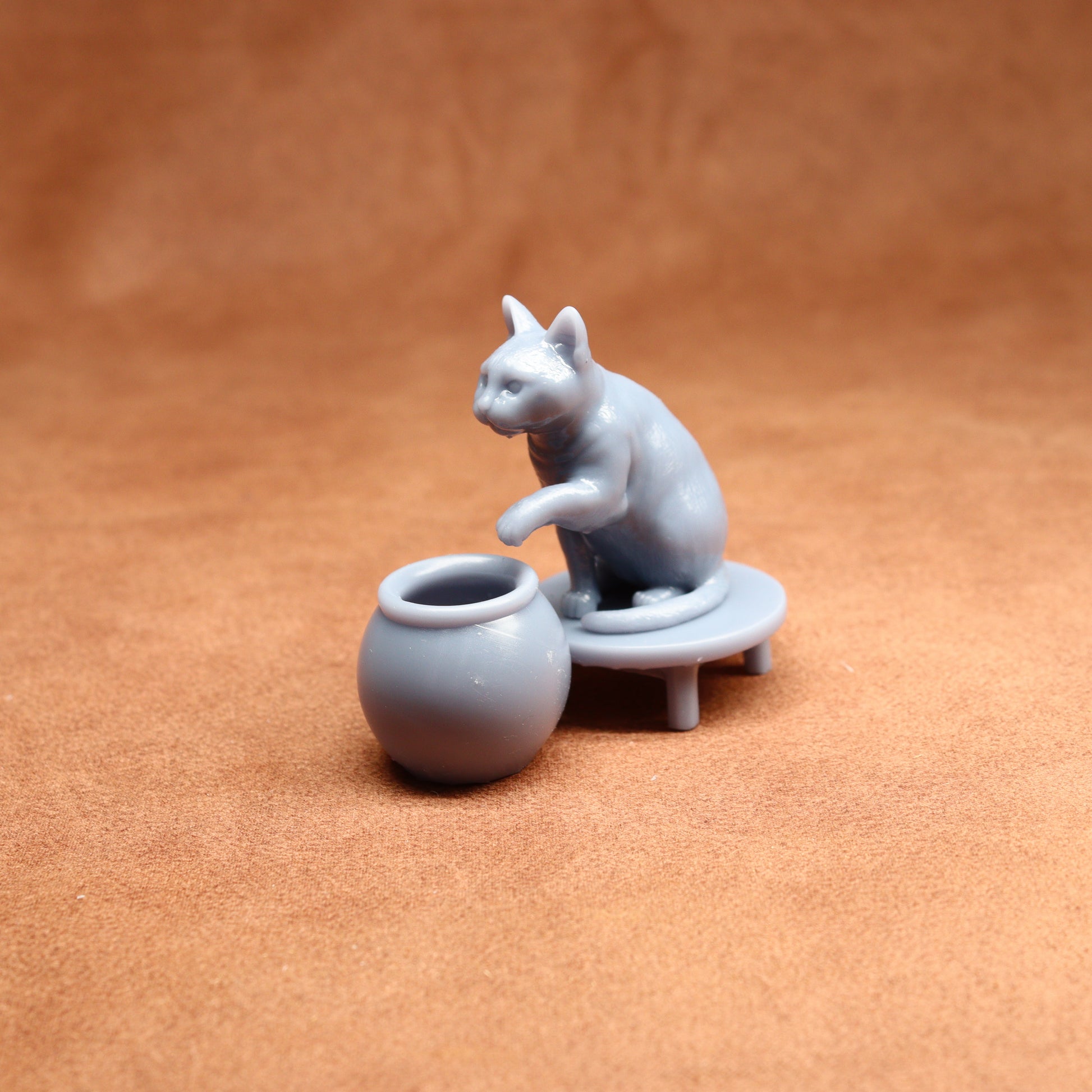 grey miniature cat figure on a brown surface