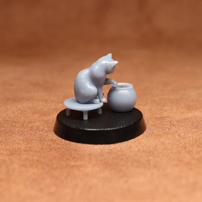 grey resin miniature cat figure on a black base with a brown background