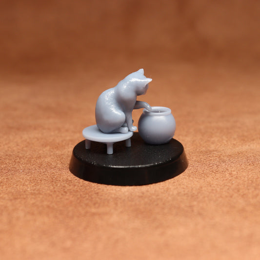 grey resin miniature cat figure on a black base with a brown background