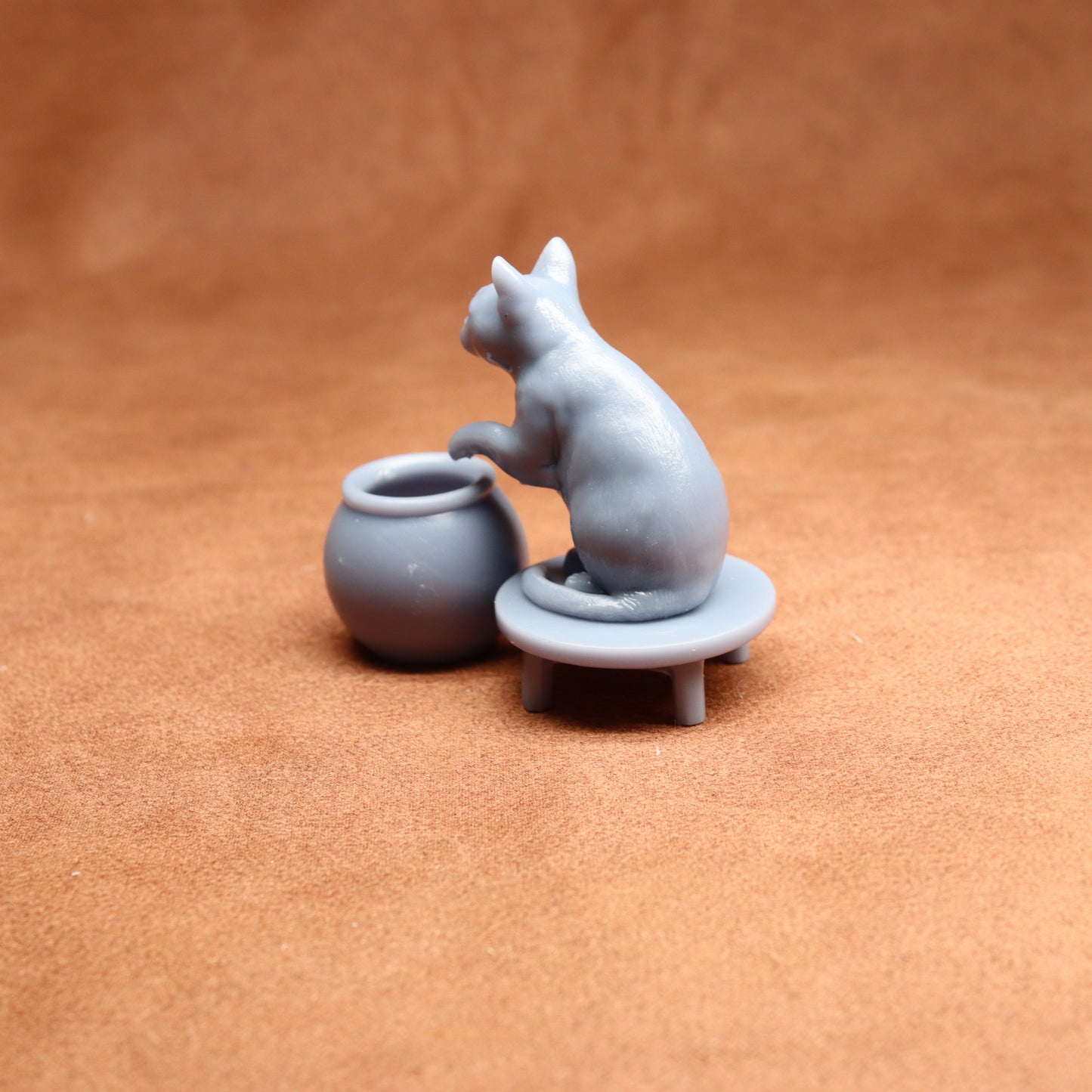 grey miniature cat figure on a brown surface