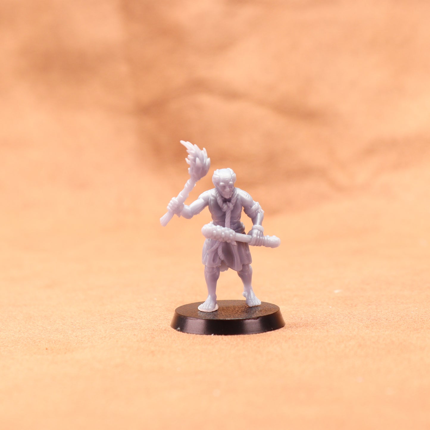 White miniature figure on a brown base against an orange background