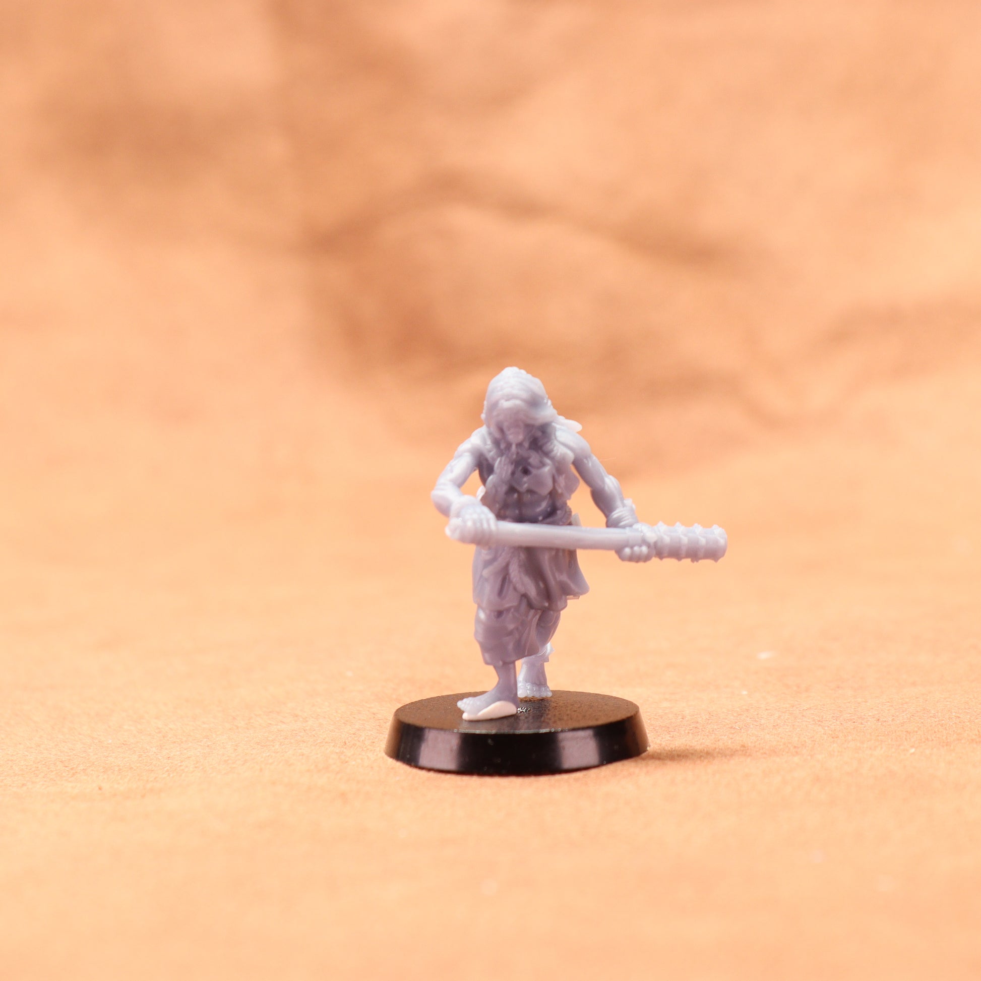 Miniature figurine of a warrior holding a spear on an orange background