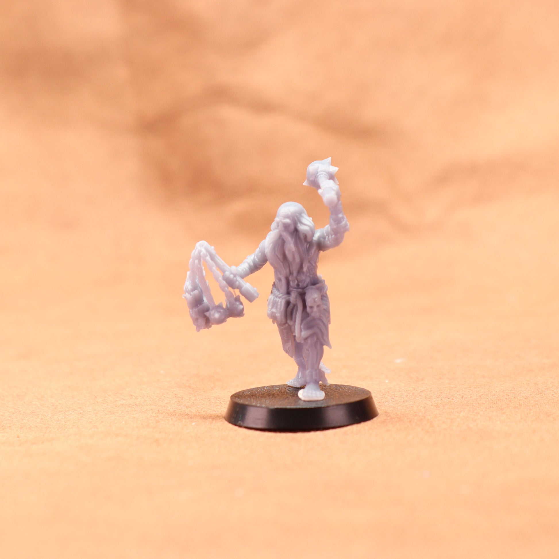 White miniature figure on a round black base against an orange background