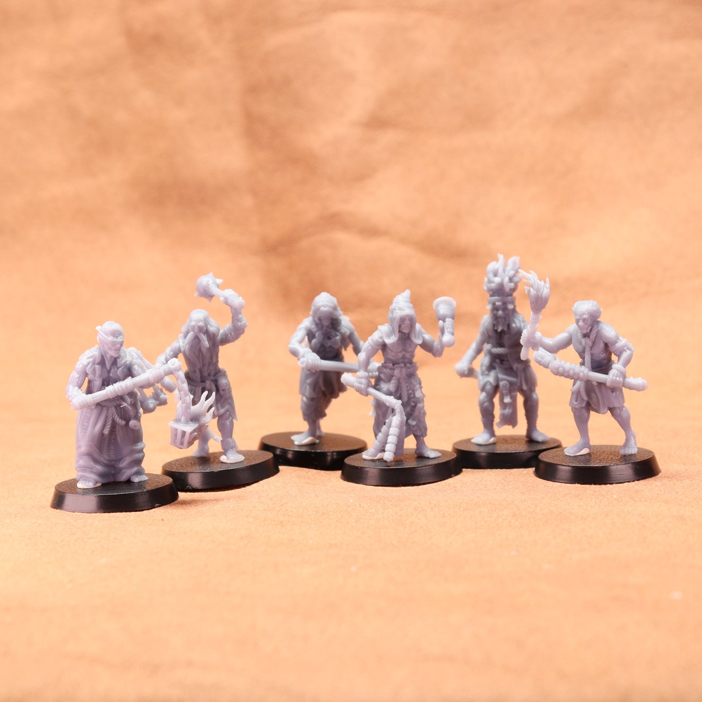 6 grey resin models on black bases on a brown background