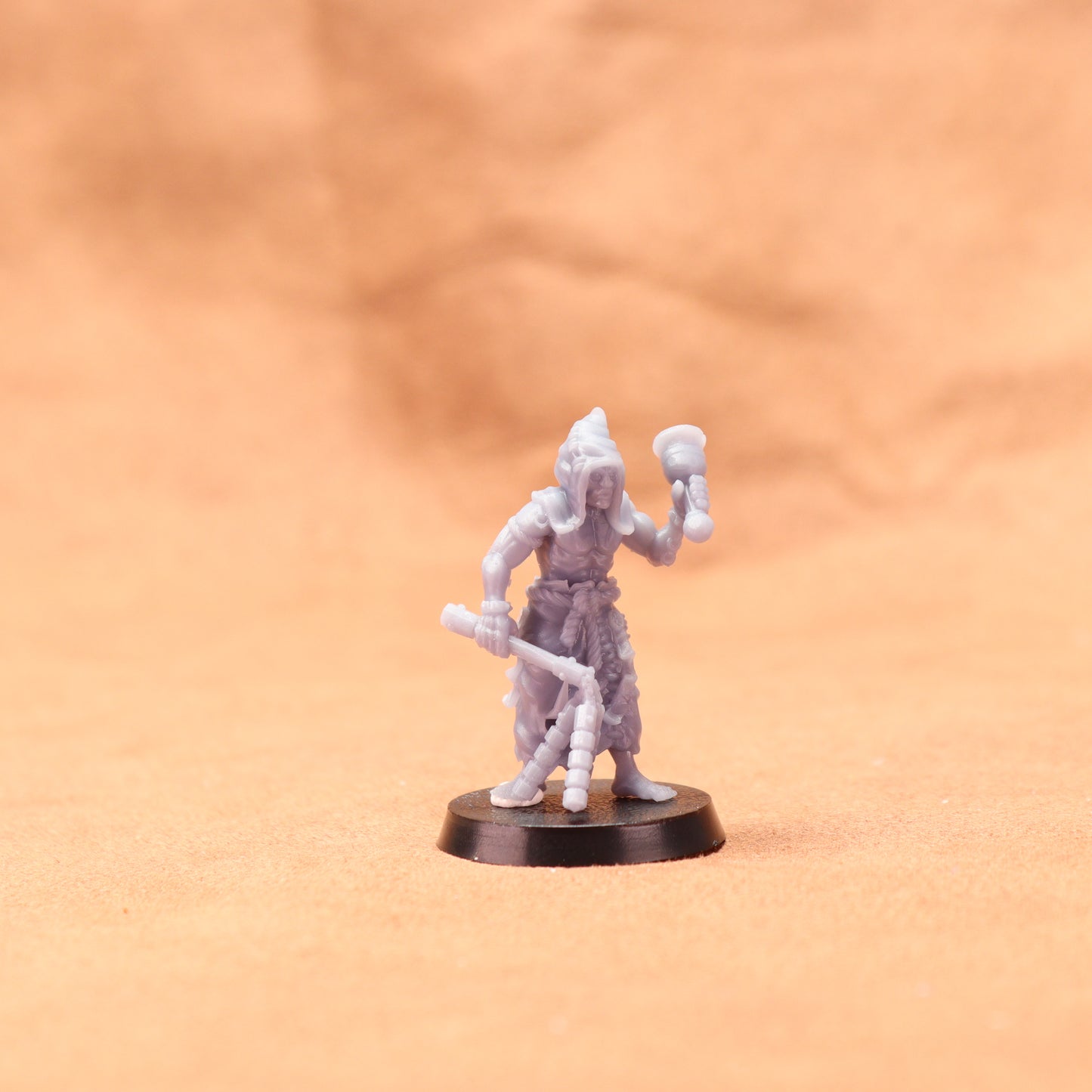 Miniature figurine on a round base against an orange background