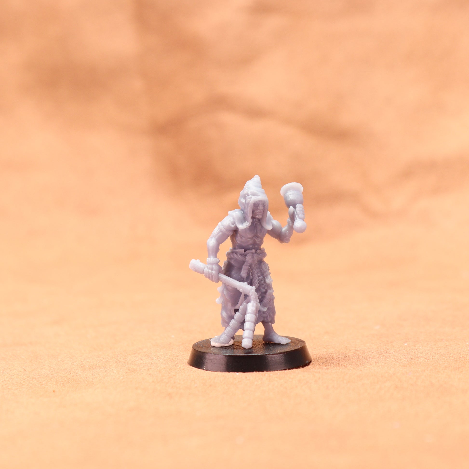 Miniature figurine on a round base against an orange background