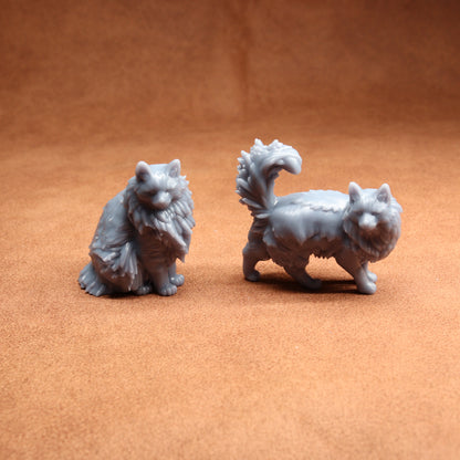 Two gray cat figurines on a brown surface