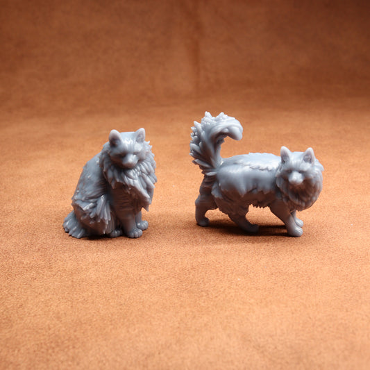 Two gray cat figurines on a brown surface