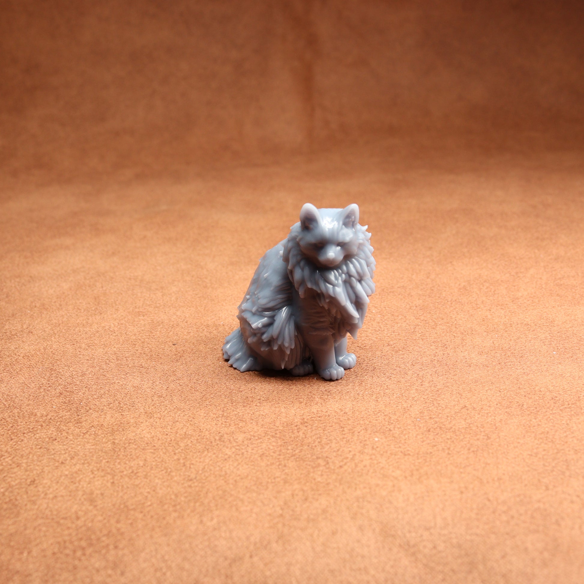 Gray cat figurine on a brown surface