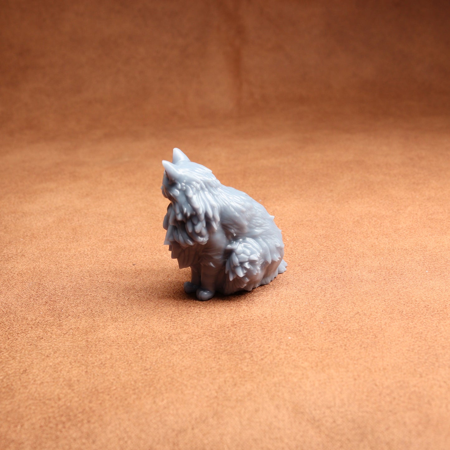 Small gray figurine of a dog on a brown surface