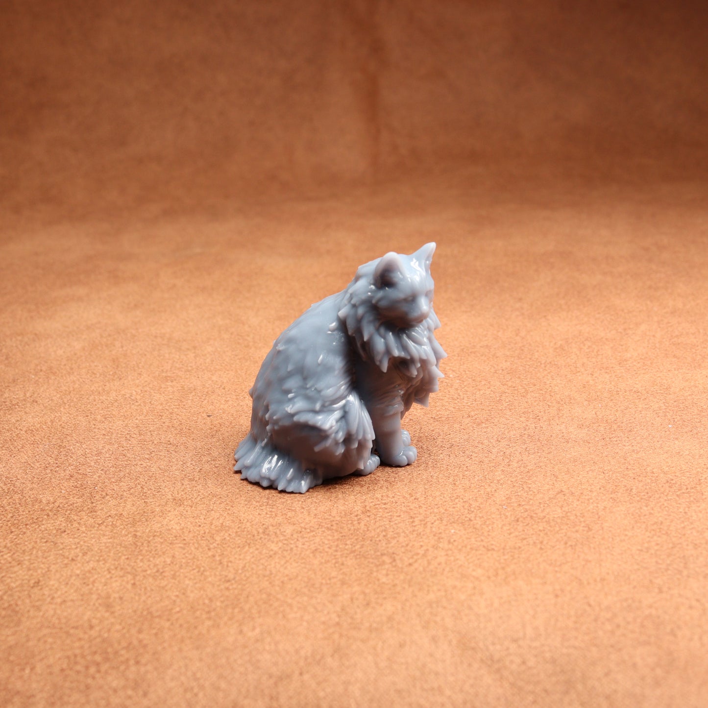 Gray cat figurine on a brown surface