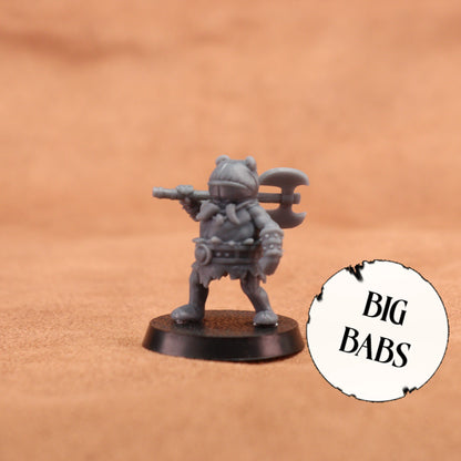 A small gray fantasy warrior miniature figurine holding a double-headed axe, standing on a round black base against a warm tan background. A white circular badge with the text 'BIG BABS' appears in the lower right corner.