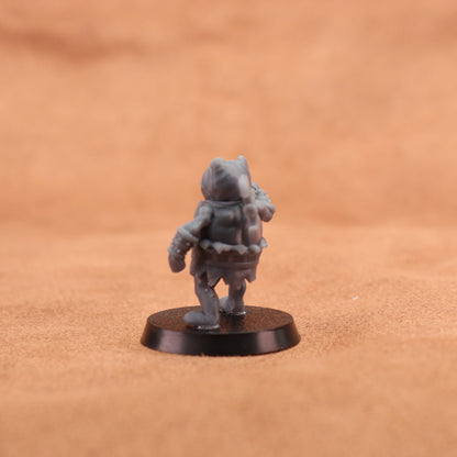 A small unpainted gray fantasy miniature figurine shown from the back on a round black base, set against a warm brown textured background.