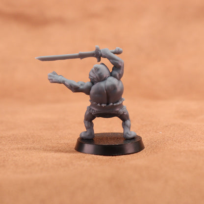 A small unpainted gray fantasy miniature figurine of a barbarian holding a sword, standing on a round black base against a warm brown textured background.