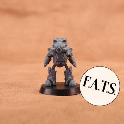 A small gray sci-fi miniature figurine standing on a round black base against a warm tan textured background, with a circular sticker reading “F.A.
