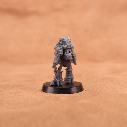 A small gray sci-fi miniature figurine standing on a round black base, photographed against a warm tan textured background.