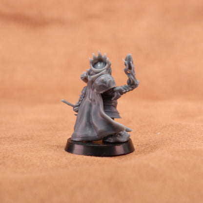 A small unpainted gray fantasy miniature figurine standing on a round black base against a warm brown textured background.