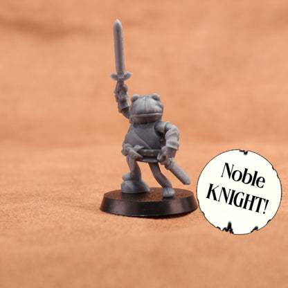 A small unpainted gray fantasy knight miniature holding a sword aloft, standing on a round black base against a warm tan textured background. A white circular badge with the text 'Noble Knight!' appears in the lower right corner.